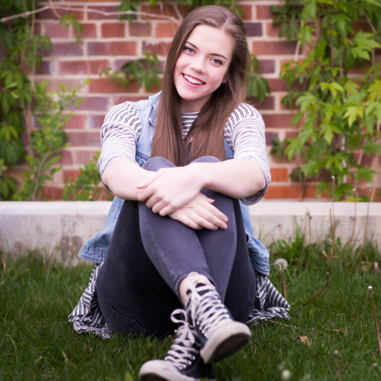 Girl Smiling In The Grass